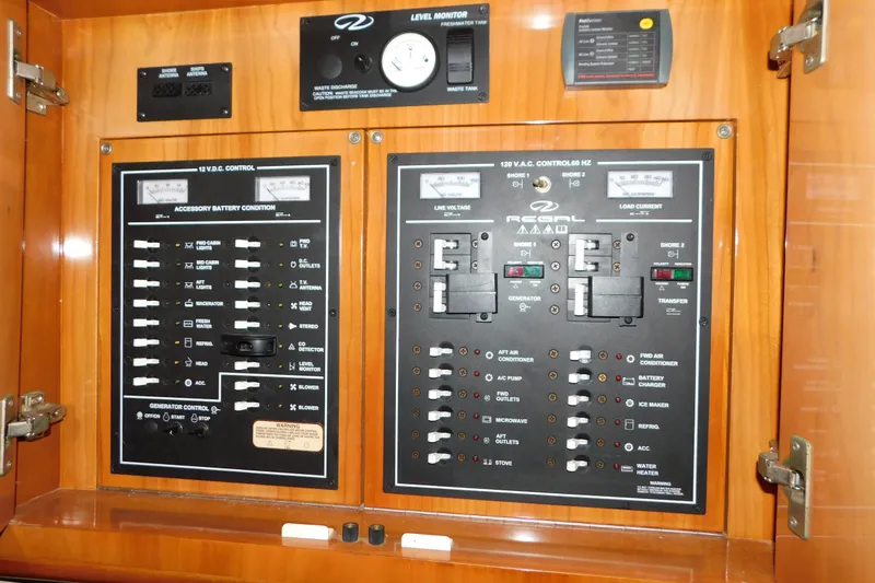 Slide: The Image of Electrical control panel of a 2004 Regal Commodore 3860 boat, featuring switches and gauges. - 58