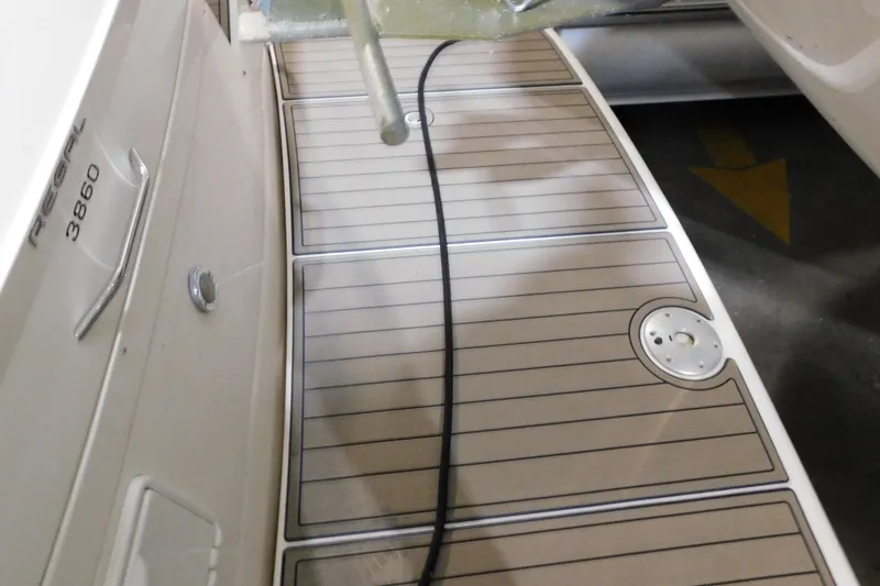Slide: The Image of 2004 Regal Commodore 3860 boat deck with sleek wood finish and visible branding. - 12