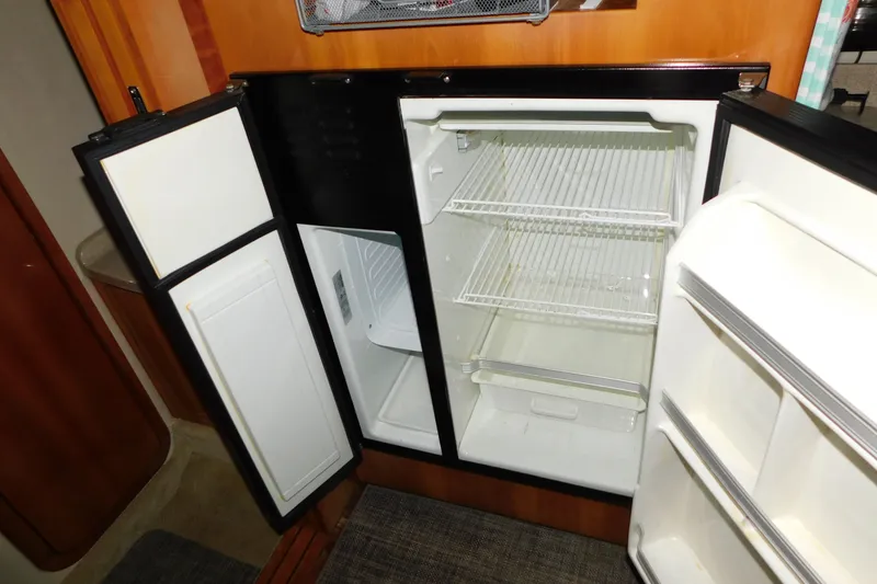 Slide: The Image of Open refrigerator inside a 2004 Regal Commodore 3860 yacht, showcasing empty shelves. - 82