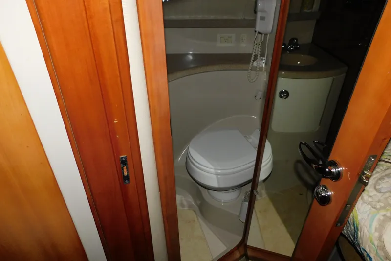 Slide: The Image of 2004 Regal Commodore 3860 yacht bathroom with wooden door and compact design. - 67