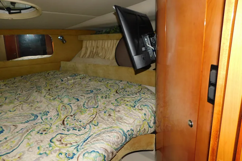 Slide: The Image of Cozy cabin interior of 2004 Regal Commodore 3860 with bed and mounted TV. - 61