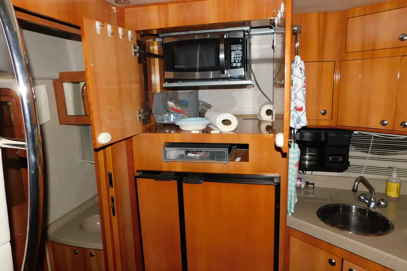 Slide: The Image of 2004 Regal Commodore 3860 yacht kitchen with microwave, fridge, and sink. - 83