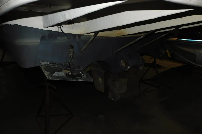 Slide: The Image of 2004 Regal Commodore 3860 boat underside on stands in a dimly lit area. - 4