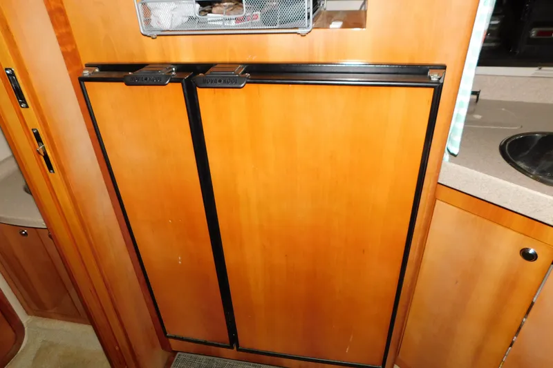 Slide: The Image of Wooden cabinetry in a 2004 Regal Commodore 3860 yacht kitchen area. - 81