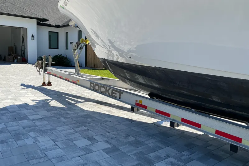 Slide: The Image of 2019 Sportsman Open 312 Center Console boat on a Rocket trailer in driveway. - 8