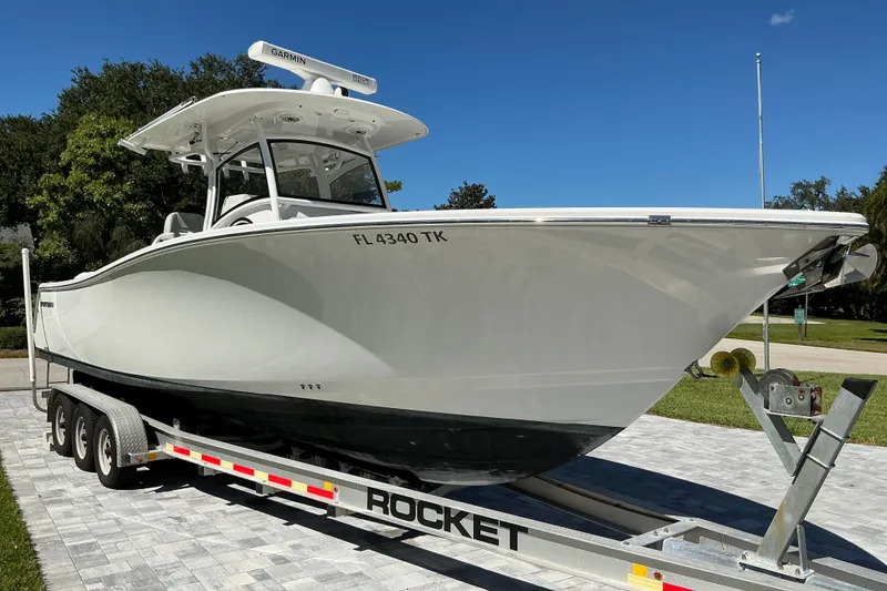 The Image of 2019 Sportsman Open 312 Center Console boat on trailer, parked outdoors. - 0