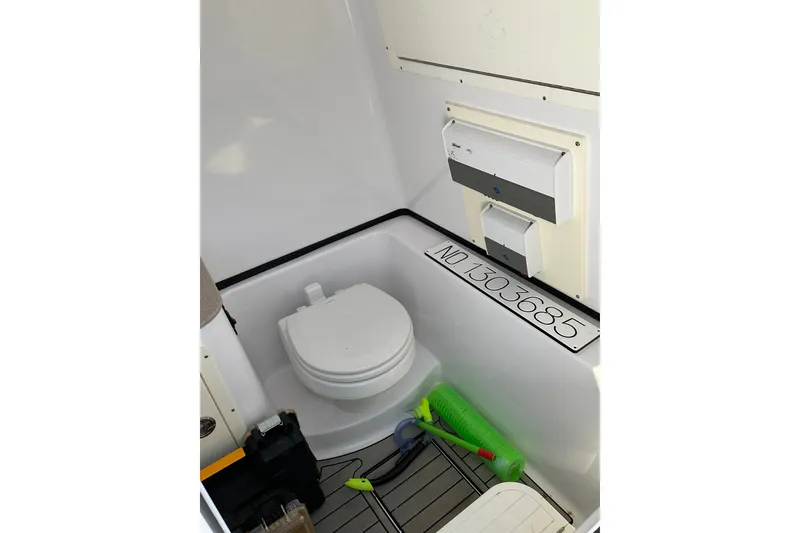 Slide: The Image of 2019 Sportsman Open 312 Center Console boat interior with toilet and storage area. - 41