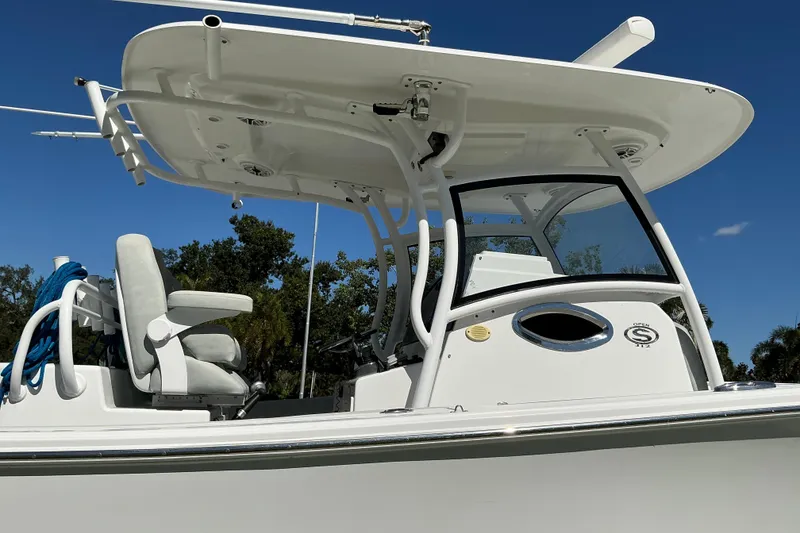 Slide: The Image of 2019 Sportsman Open 312 Center Console boat with T-top and seating, under clear blue sky. - 15