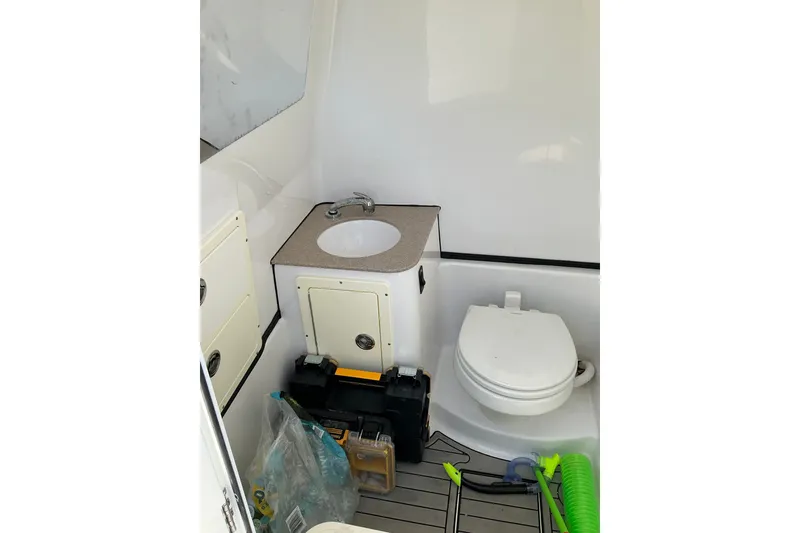 Slide: The Image of 2019 Sportsman Open 312 Center Console boat interior with sink and toilet. - 40