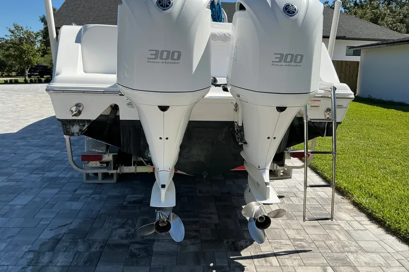 Slide: The Image of 2019 Sportsman Open 312 Center Console with twin Yamaha 300 engines, parked on driveway. - 10