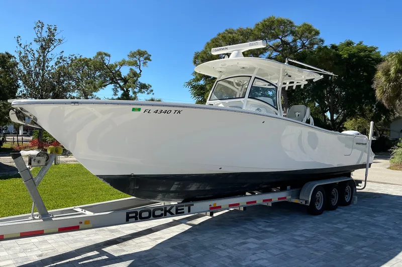 Slide: The Image of 2019 Sportsman Open 312 Center Console boat on trailer, parked outdoors. - 2
