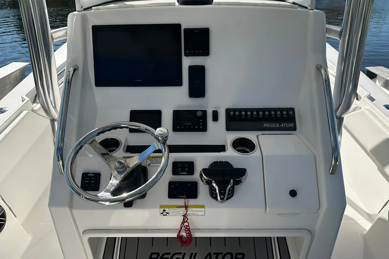 Slide: The Image of Helm of 2016 Regulator 28 Forward Seating boat with steering wheel and controls. - 24