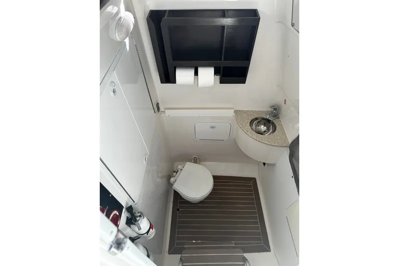 Slide: The Image of 2016 Regulator 28 Forward Seating boat bathroom with sink and toilet. - 18