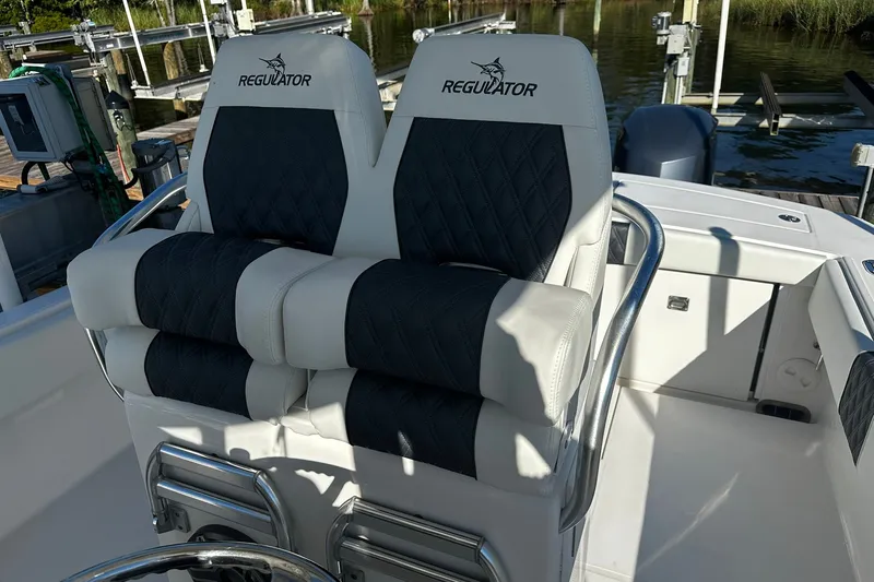 Slide: The Image of 2016 Regulator 28 Forward Seating boat with dual cushioned seats and stainless steel railings. - 26