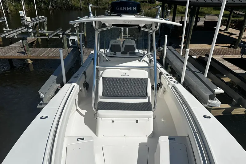 Slide: The Image of 2016 Regulator 28 Forward Seating boat docked, featuring Garmin equipment and spacious seating. - 14