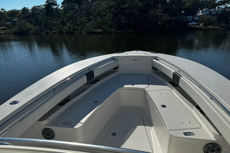 Slide: The Image of 2016 Regulator 28 Forward Seating boat on calm water, surrounded by trees. - 20