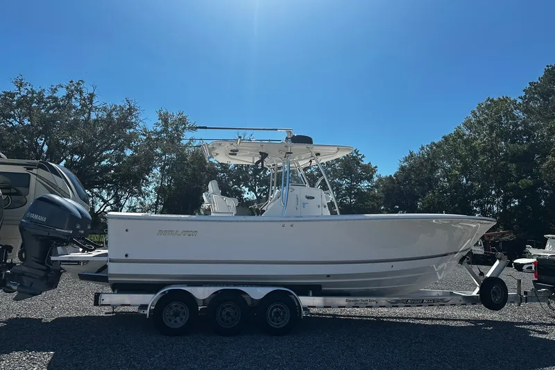 Slide: The Image of 2016 Regulator 28 Forward Seating boat on trailer under clear blue sky. - 3