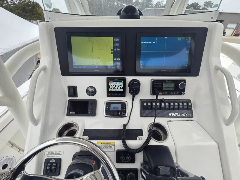 Slide: The Image of The image shows the helm of a 2016 Regulator FS boat with multiple screens and controls. - 5