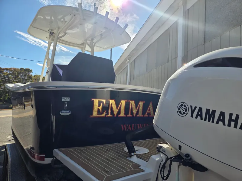 Slide: The Image of A 2016 Regulator FS boat with Yamaha engine, docked with a blue sky in the background. - 2