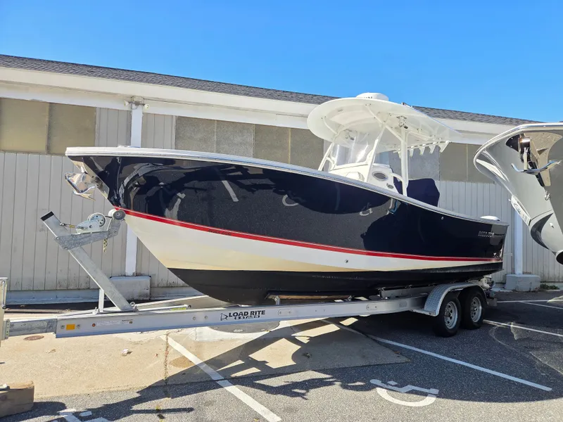 Slide: The Image of A 2016 Regulator FS on a trailer, featuring a dark blue hull with a red stripe. - 1