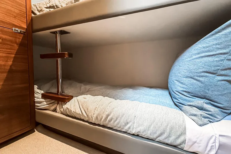Slide: The Image of Bunk bed in 2026 Princess S65 Sportbridge yacht cabin, featuring wooden ladder and cozy bedding. - 65