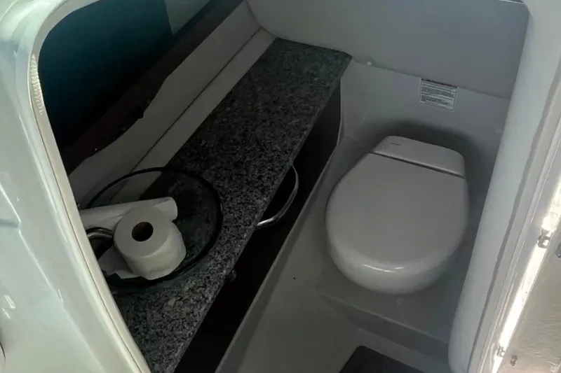 Slide: The Image of 2022 Crownline 290 XSS boat bathroom with modern toilet and granite countertop. - 8