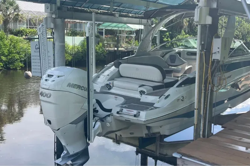 Slide: The Image of 2022 Crownline 290 XSS boat with Mercury 400 engine on a lift by the water. - 3