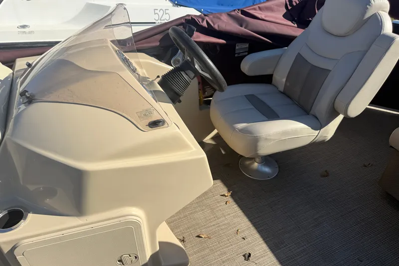 Slide: The Image of Captain's chair and console of a 2018 Sweetwater 22 boat, featuring a steering wheel. - 10