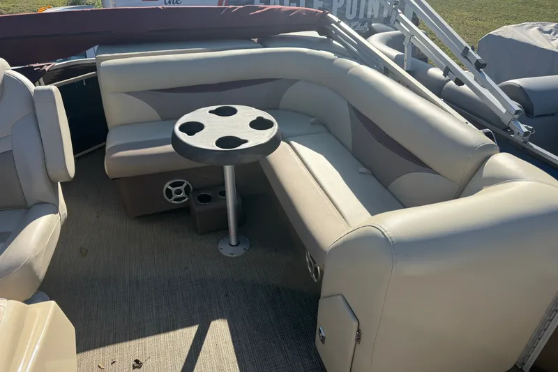 Slide: The Image of Interior of a 2018 Sweetwater 22 boat with beige seating and cup holder table. - 5