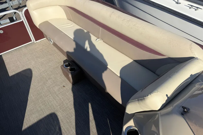 Slide: The Image of 2018 Sweetwater 22 boat interior with beige seating and cup holders. - 9