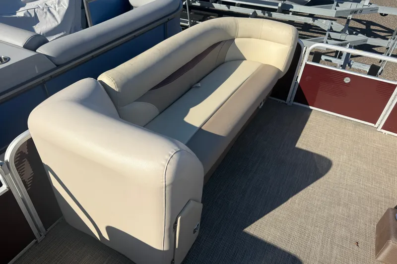 Slide: The Image of 2018 Sweetwater 22 boat interior with beige seating and carpeted floor. - 8