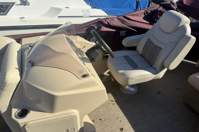 Slide: The Image of Captain's chair and console on a 2018 Sweetwater 22 boat, beige interior. - 7