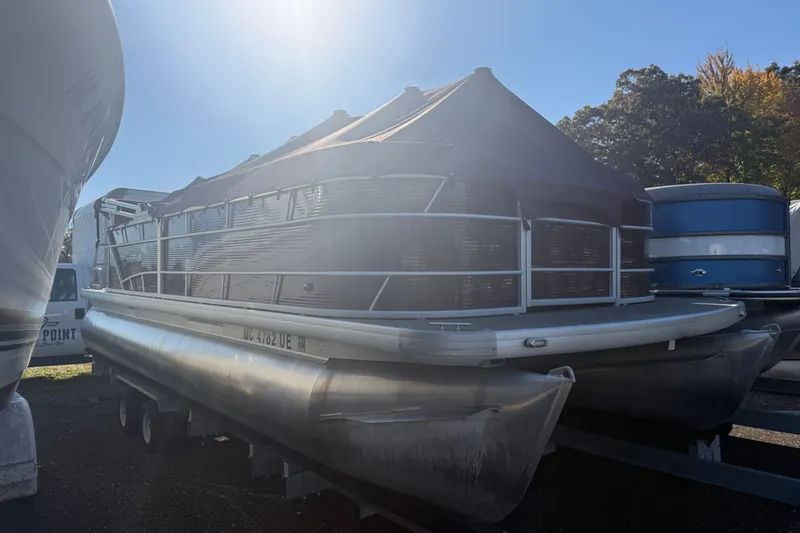 Slide: The Image of 2018 Sweetwater 22 pontoon boat with cover, parked outdoors in sunlight. - 1
