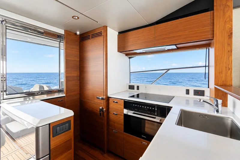 Slide: The Image of Luxurious 2024 Princess V60 yacht kitchen with ocean view, featuring modern appliances and sleek wood finishes. - 3
