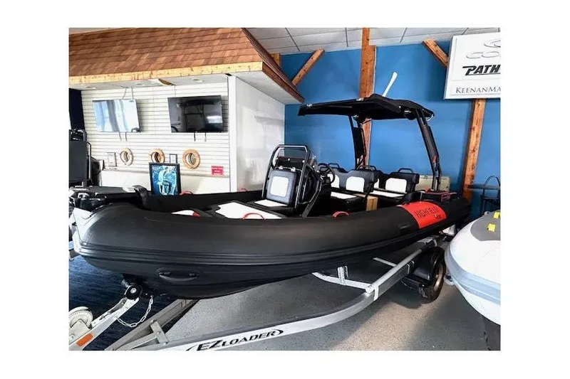 Slide: The Image of 2026 Highfield Velox 560 boat displayed indoors on a trailer. - 13