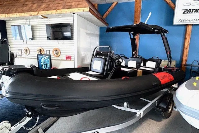 Slide: The Image of 2026 Highfield Velox 560 inflatable boat displayed indoors on a trailer. - 1