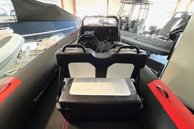 Slide: The Image of 2026 Highfield Velox 560 boat interior with black and white seating and steering console. - 5
