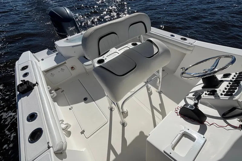 Slide: The Image of 2012 Sea Fox 256 Center Console boat interior with helm and seating, on water. - 11
