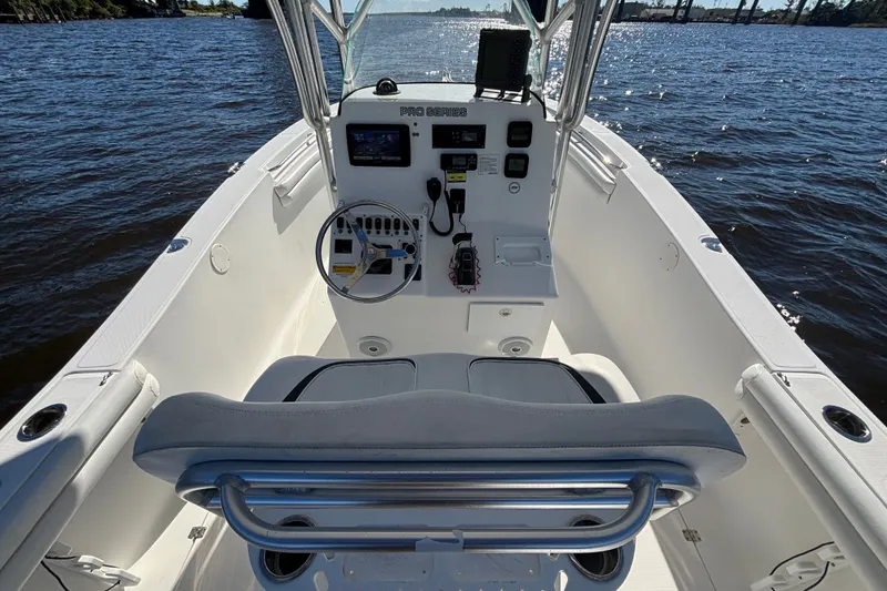 Slide: The Image of 2012 Sea Fox 256 Center Console boat interior with steering wheel and controls on water. - 12
