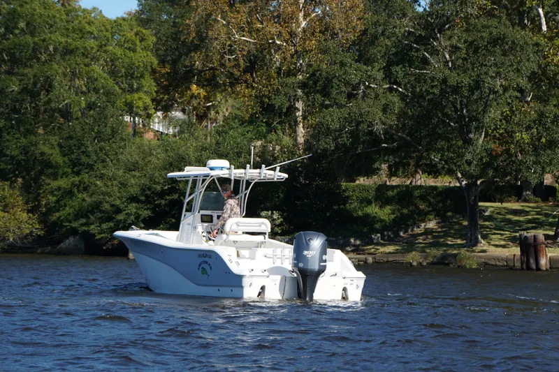 Slide: The Image of 2012 Sea Fox 256 Center Console boat cruising on a river with lush green trees. - 4