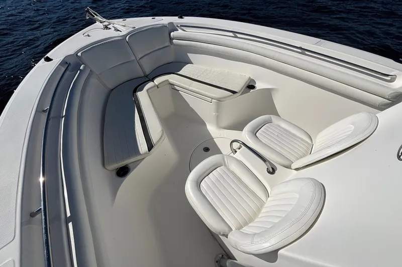 Slide: The Image of 2012 Sea Fox 256 Center Console boat interior with white seating and ocean backdrop. - 8