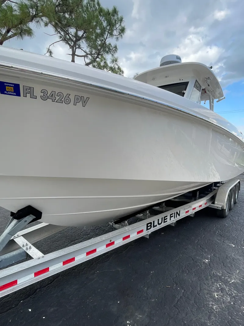 Slide: The Image of 2014 Everglades 325 Center Console boat on Blue Fin trailer, parked outdoors. - 3