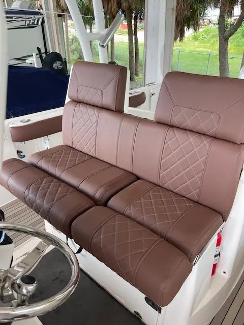 Slide: The Image of Brown leather seating on 2014 Everglades 325 Center Console boat, featuring diamond stitching. - 23