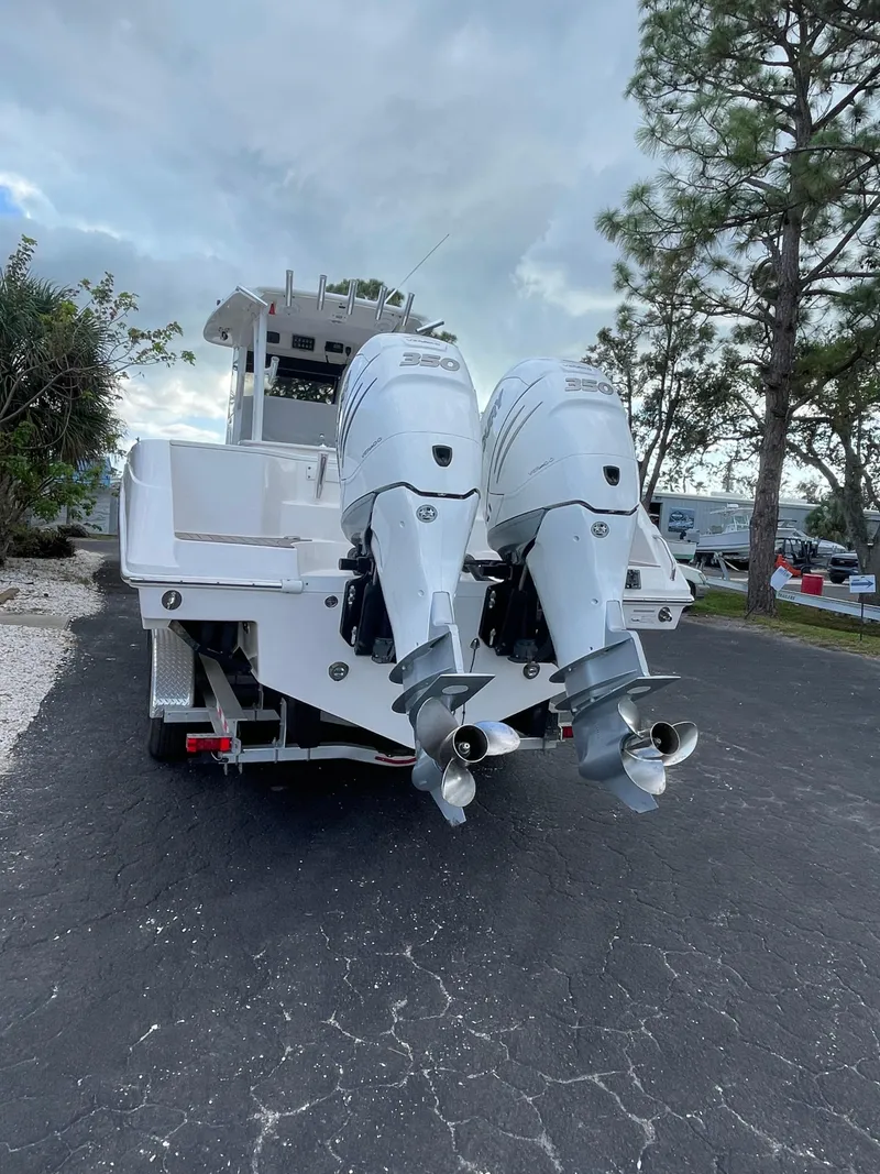 Slide: The Image of 2014 Everglades 325 Center Console boat with dual outboard engines on a paved road. - 7