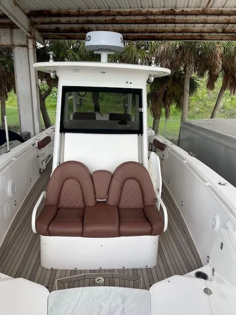 Slide: The Image of 2014 Everglades 325 Center Console boat with brown seating under a canopy. - 27