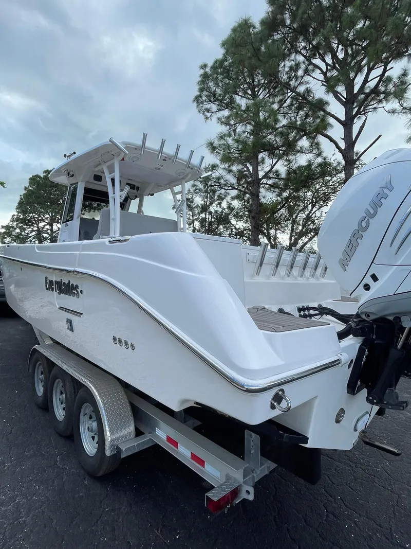 Slide: The Image of 2014 Everglades 325 Center Console boat on trailer, featuring Mercury engine. - 12