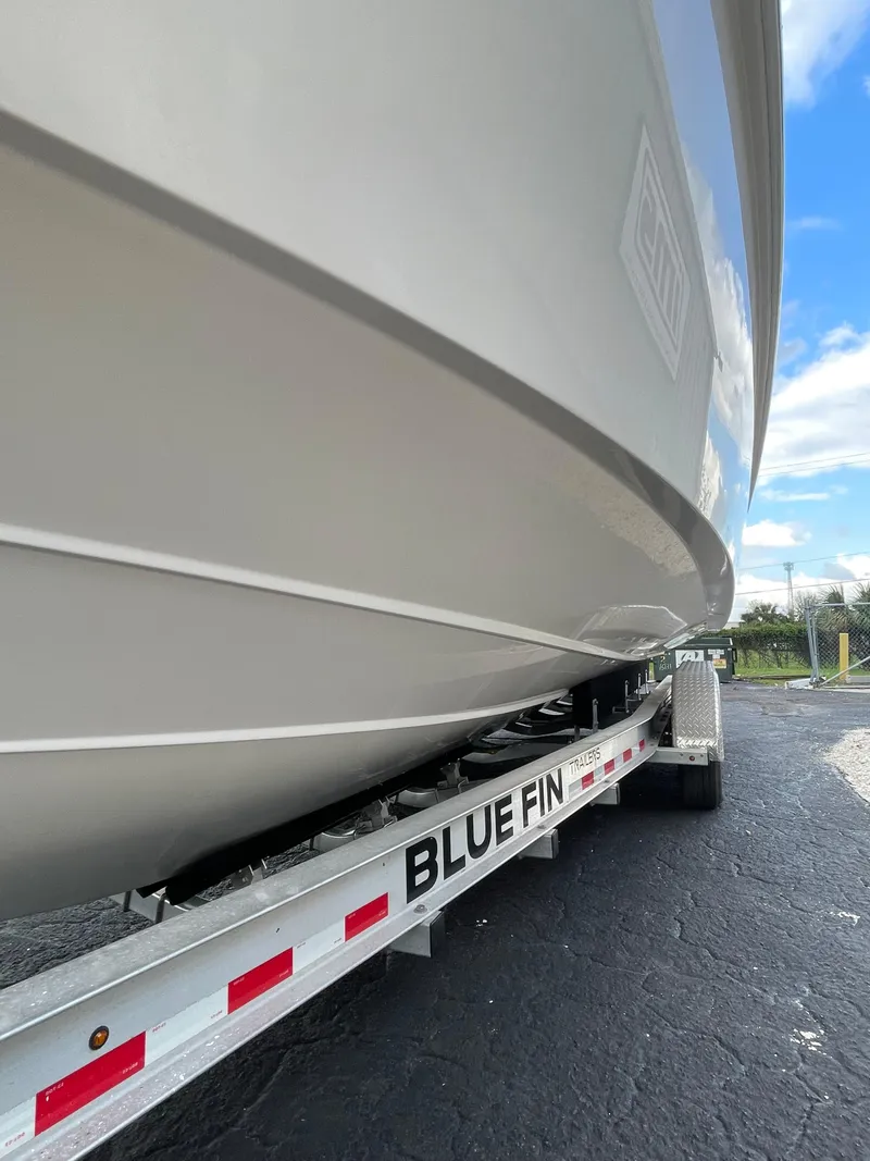 Slide: The Image of 2014 Everglades 325 Center Console boat on Blue Fin trailer, side view. - 2