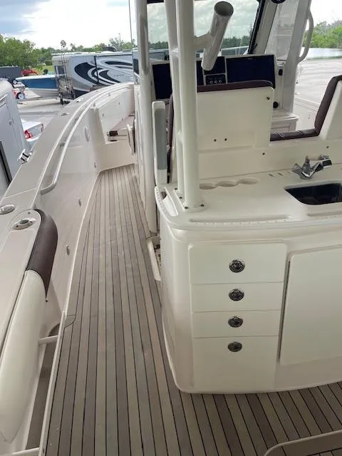 Slide: The Image of 2014 Everglades 325 Center Console boat interior with seating and storage compartments. - 28