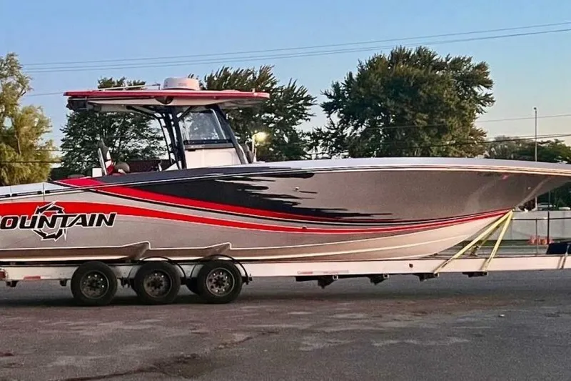 Slide: The Image of 2022 Fountain 38 SC boat on trailer, featuring sleek design and vibrant graphics. - 11