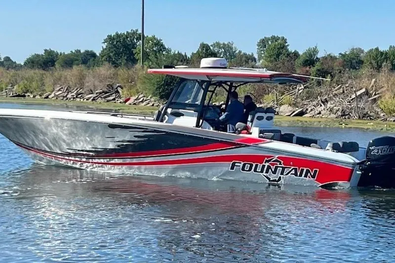 Slide: The Image of 2022 Fountain 38 SC boat cruising on a calm lake with scenic background. - 2